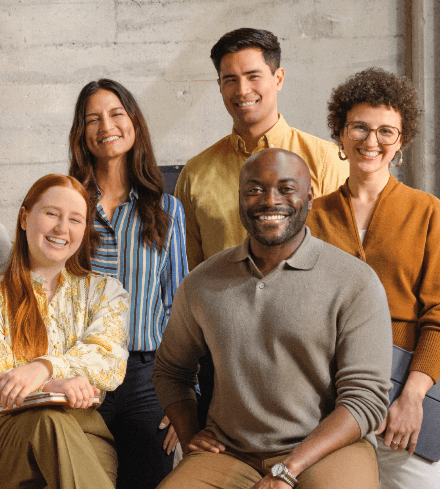 Group of employees smiling together in warm toned office