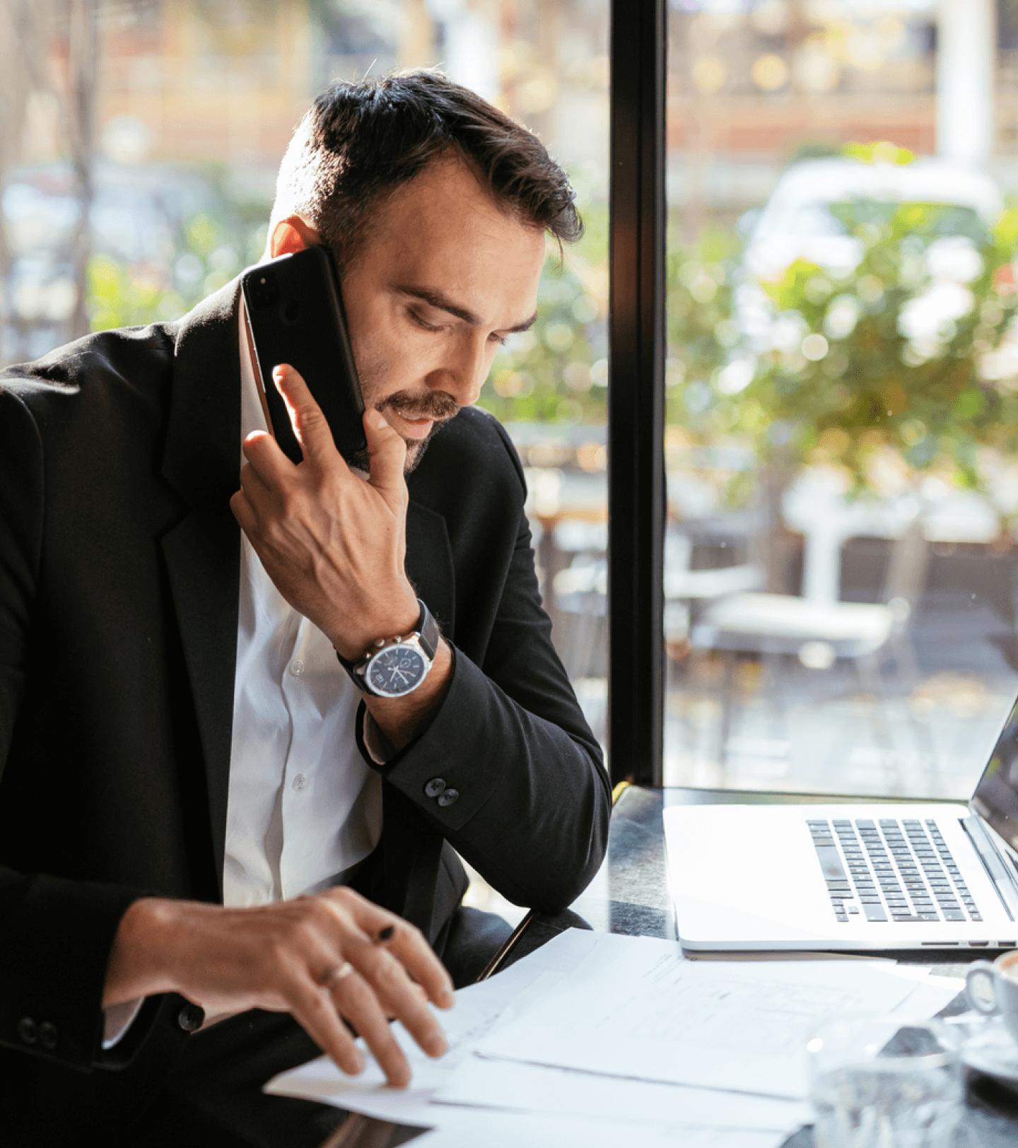 Man holding a cellphone while looking at documents