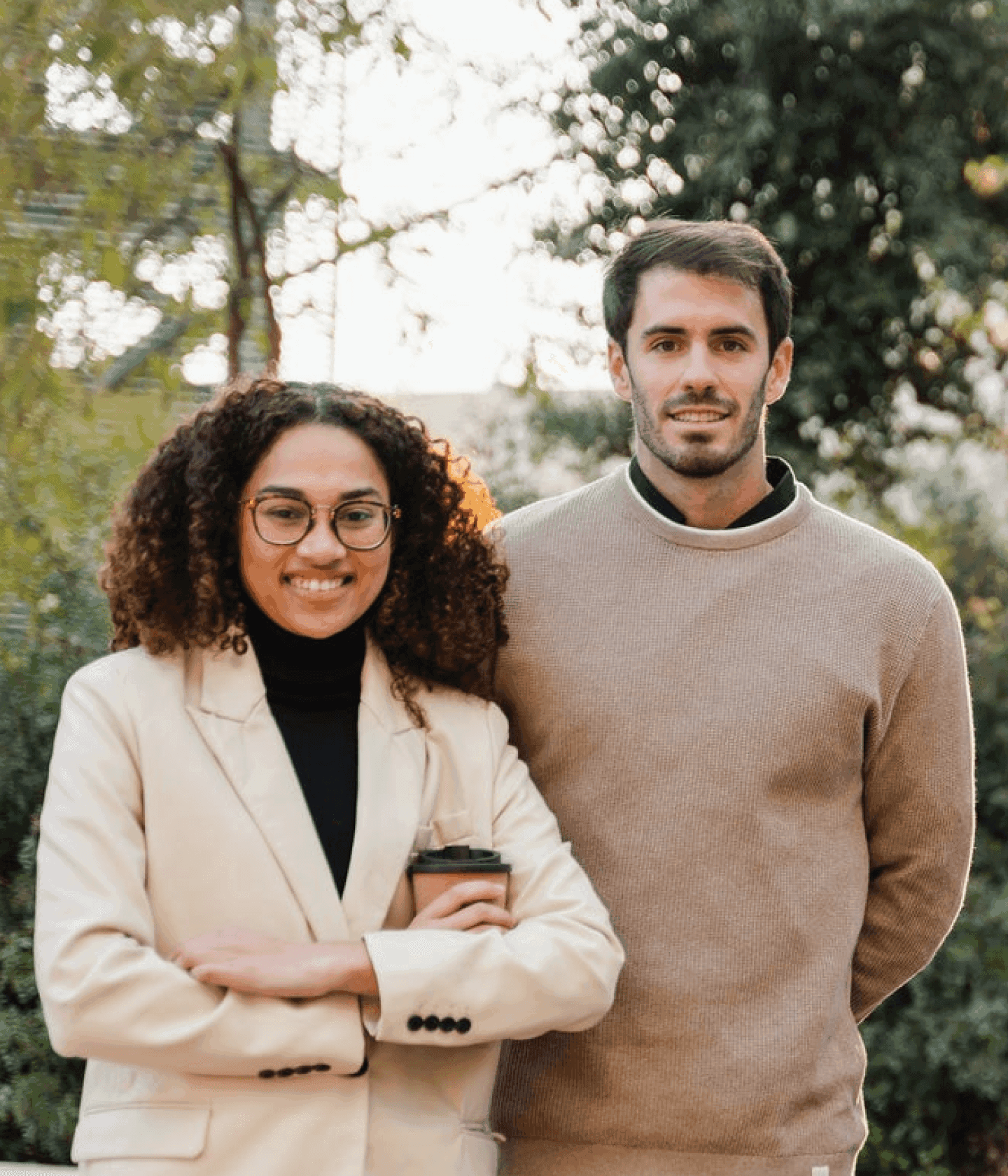 Two office workers posing outside green background